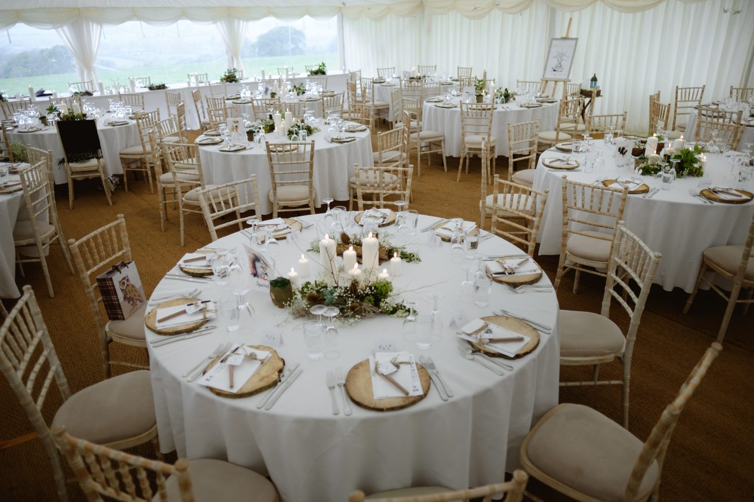 5ft 6 Round tables with log slice place mats • The Marquee Hire Company